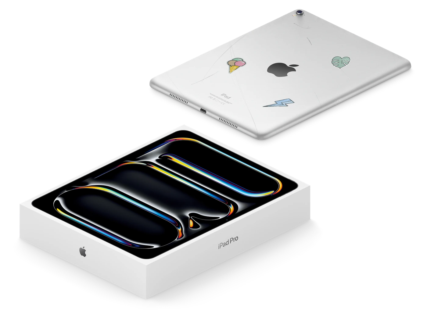 A used iPad with stickers above a brand-new iPad Pro in its box